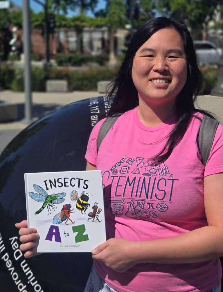 Me holding my book at Livermorium Plaza